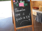 a chalk board with a sign on it in front of a store