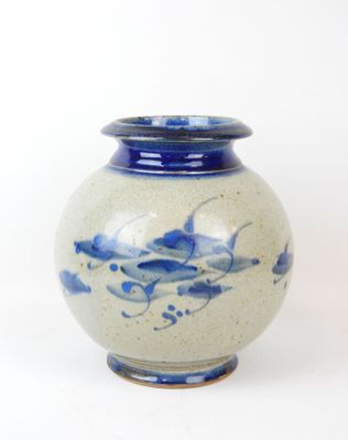 a blue and white vase sitting on a white surface