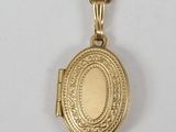 un collier « Locke » en or, orné d'un petit pendentif ovale « Locke » suspendu à une chaîne