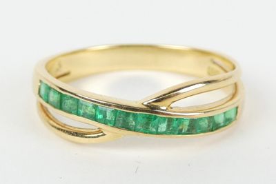 un gros plan d'une bague en or sertie d'émeraudes