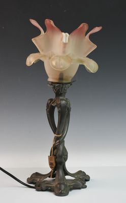une lampe posée sur une table sur laquelle se trouve une fleur