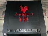 une enseigne noire et rouge sur laquelle figure un coq rouge