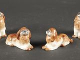 trois petites figurines représentant des chiens assis sur une surface noire