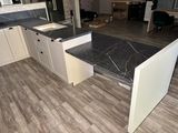 a kitchen with a marble counter top and white cabinets