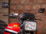 a red and black motorcycle parked in front of a brick wall