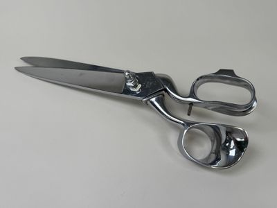 a pair of scissors sitting on a white surface