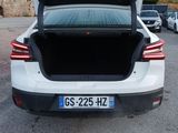 a white car with its trunk open in a parking lot