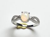 Une bague en oplite et diamant est présentée sur un fond blanc