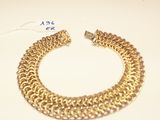 an image of a gold chain bracelet on a white surface