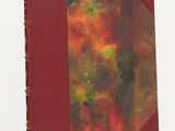 a close up of a book with a red cover on a white surface