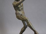 statue en bronze représentant un homme tenant un oiseau sur un rocher