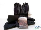 a pair of gloves, a laptop and a book on a table