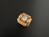 un gros plan d'un diamant serti dans une bague en or, posé sur une surface noire