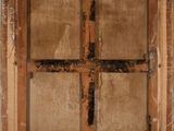 an old wooden window with a cross on the outside of it