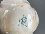 a white vase with a green design on it