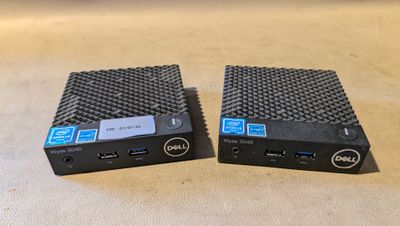 two dell desktop computers sitting on top of each other on a table