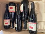 several bottles of wine in a cardboard box on a table