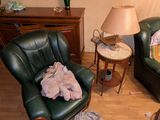 un salon avec un canapé, un fauteuil, une table et une lampe
