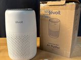 an air purifier sitting on top of a wooden table next to a box