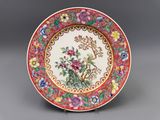 une assiette rouge et blanche ornée de fleurs et d'oiseaux