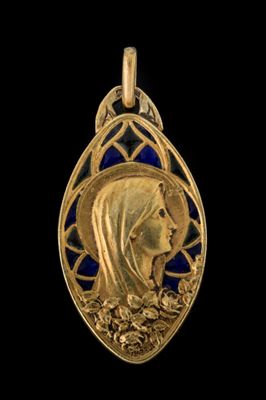 Gros plan sur un pendentif en or orné d'un visage de femme