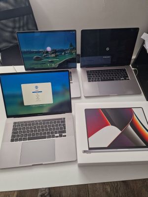 three laptops are sitting on a table with a mouse and a keyboard