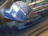 a blue car that has a mirror on the side of it