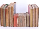 several old books stacked on top of each other on a white surface