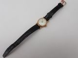 a close up of a wrist watch on a white surface