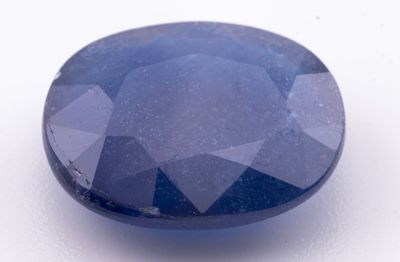 une pierre de saphir bleu sur une surface blanche