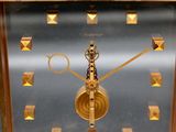 a gold clock with gold studs on the face
