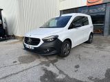 une camionnette blanche garée devant un bâtiment dans un parking