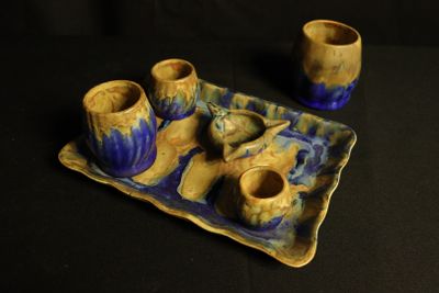 une photo d'un plateau bleu et jaune sur lequel sont posées des tasses et des soucoupes