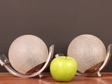a green apple sitting on a table next to a pair of globes
