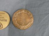a gold medal and a gold coin on a blue cloth