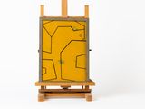 chevalet de peinture avec un tableau jaune sur fond blanc