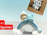 a small figurine of a baby sleeping on top of a rainbow