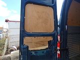 a blue van with the door open and a wooden seat in the back