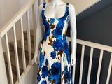 La robe est bleue et blanche, avec des fleurs bleues.
