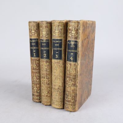 trois vieux livres posés l'un sur l'autre sur une surface blanche