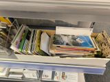 a drawer full of books and magazines on the floor