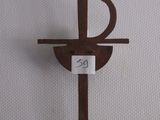 une croix en bois sur laquelle est accrochée une pancarte, posée sur une surface blanche