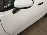 a small white car with a side mirror on the side of it
