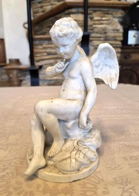 an image of a statue of a child sitting on top of a table