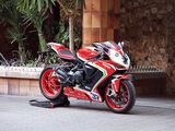 une moto rouge et noire garée devant un immeuble