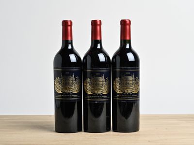 trois bouteilles de vin posées sur une table en bois
