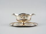 un service en argent ancien composé d'une assiette et d'une soucoupe posée dessus