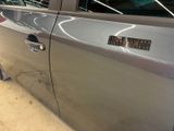 a silver car that has a sticker on the side of it