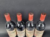 four bottles of wine are lined up on a black surface