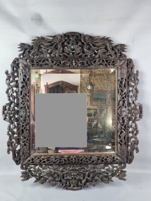 an ornate mirror with a silver frame on a white background